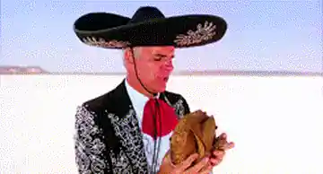 Un homme au sombrero dévore une cuisse de poulet